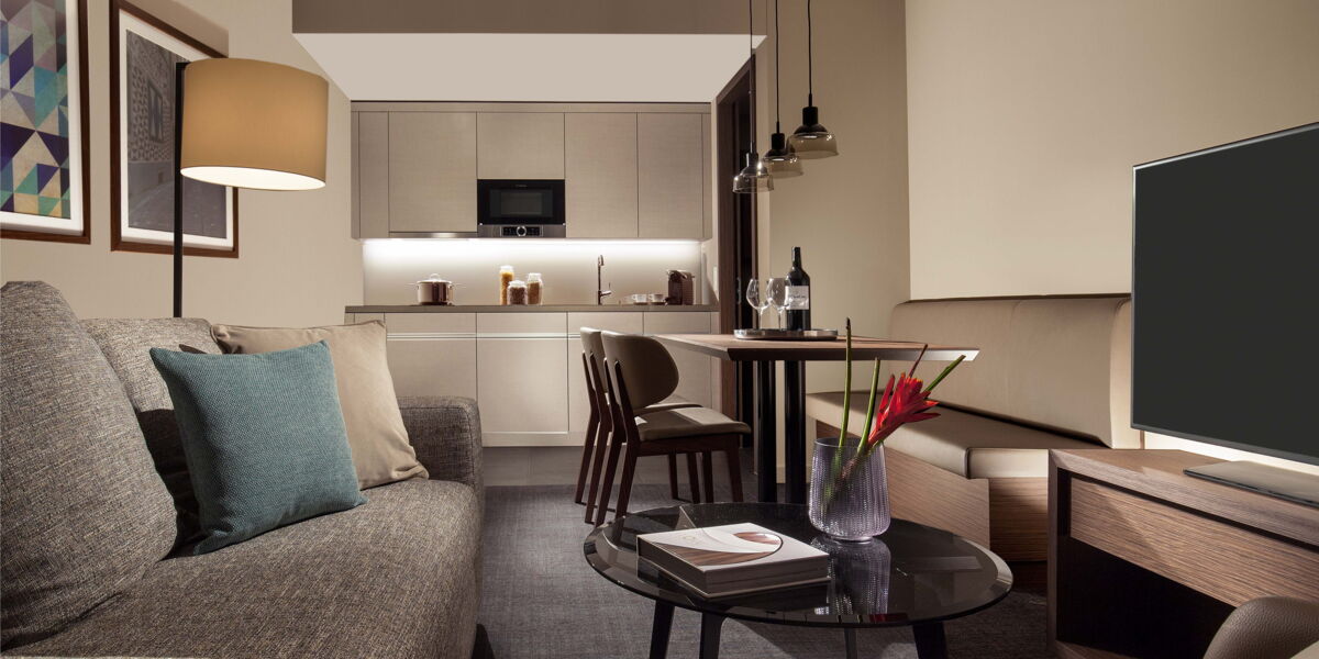 Acasa Suite with sofa, TV, dining table and kitchenette